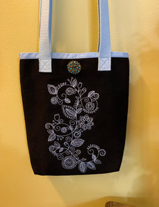 Black tote bag embroidered with a blue Mehendi design